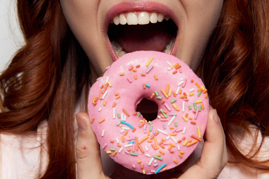 Woman,Eating,A,Donut,Close-up,,Delicious,,Sweet,,Sweet,Tooth